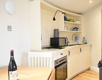 Our Self Catering accommodation kitchen contains oven microwave dining table